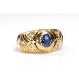 A sapphire and diamond ring The oval-cut sapphire, to a decorative band inlaid with brilliant-cut