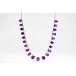 An amethyst fringe necklace The graduated series of oval cabochon amethysts, each in a four-claw