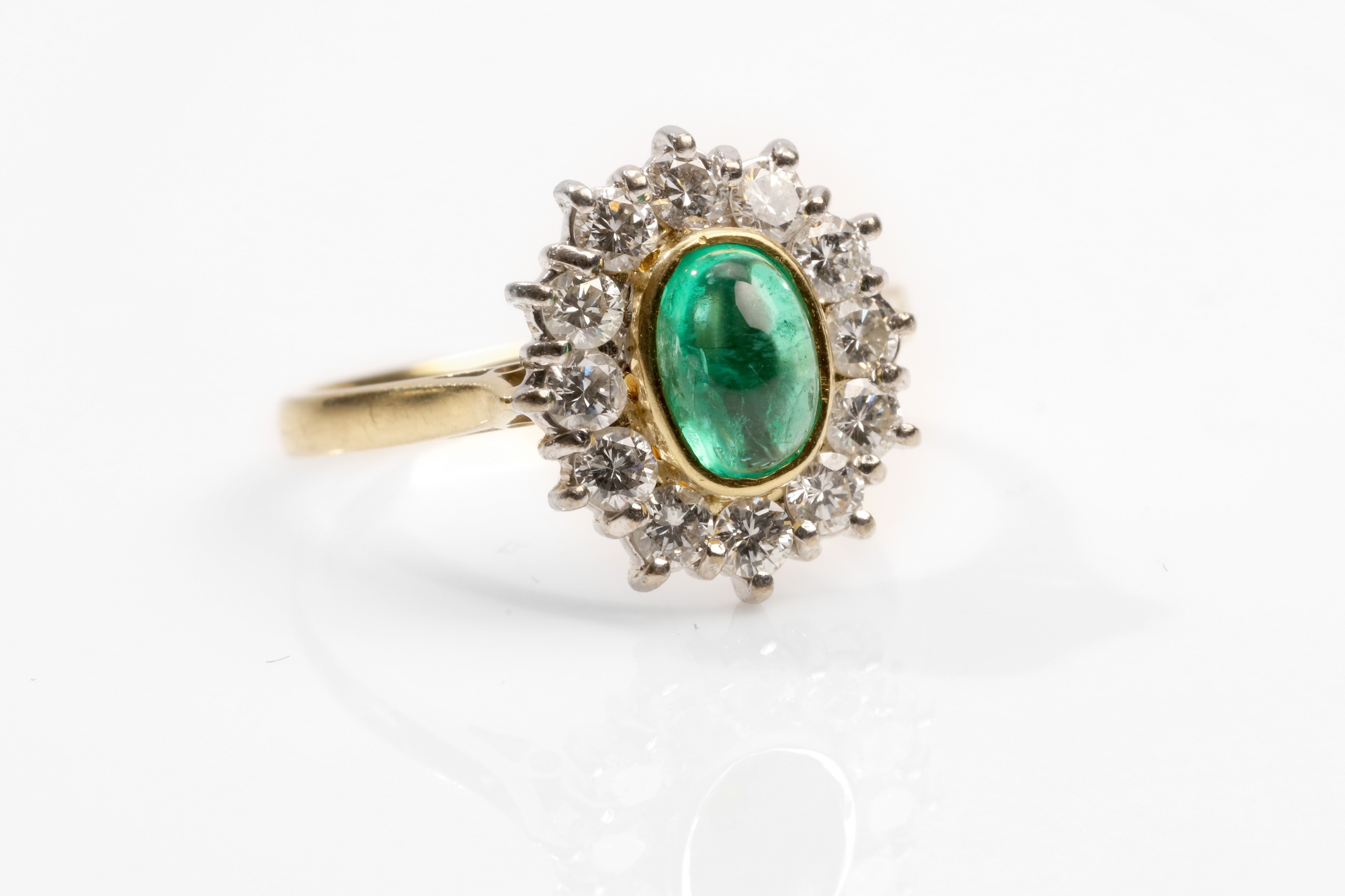 An emerald and diamond cluster ring, 1989 The collet-set oval-cut cabochon emerald, within a - Image 2 of 3