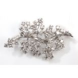 A diamond leaf brooch, circa 1965 The stem set with baguette-cut diamonds, flanked by clusters of