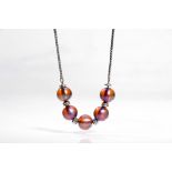 A WMF bead necklace Set with five 12.6-12.8mm iridescent beads of purple hue, to a fancy-link