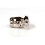 A diamond dress ring The wide band inlaid with a line of brilliant-cut diamonds, centrally featuring