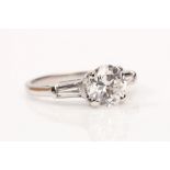 A diamond single-stone ring The brilliant-cut diamond, in a four-claw setting, between tapered