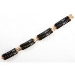 An onyx bracelet Designed as pairs of contoured onyx batons, linked by Chinese characters, length