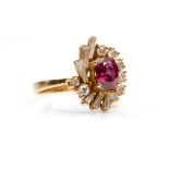 A ruby and diamond dress ring The oval-cut ruby, within a surround of tapered baguette and