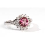 A pink sapphire and diamond ring The cushion-shaped pink sapphire, within a surround of brilliant-