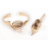 A gold and rutilated quartz bangle and pendant suite, by Bent Gabrielsen, 1976-77 The 14 carat