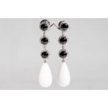 A pair of onyx, white chalcedony and diamond pendent earrings The graduated trio of circular