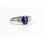 A sapphire and diamond three-stone ring  The oval-cut sapphire, between brilliant-cut diamonds,