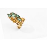 A dress ring, circa 1975 The elongated openwork plaque, set with marquise-cut green paste and step-