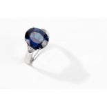 A sapphire and diamond ring The oval-cut sapphire, weighing 6.96 carats, in a four-claw setting,