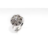 A diamond dress ring The brilliant-cut diamond within a surround of single-cut diamonds and