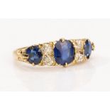 A sapphire and diamond ring Set with three oval-cut sapphires, spaced by pairs of old brilliant-