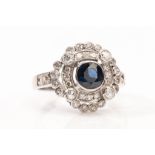 A sapphire and diamond dress ring The collet-set circular-cut sapphire, in a pierced surround of