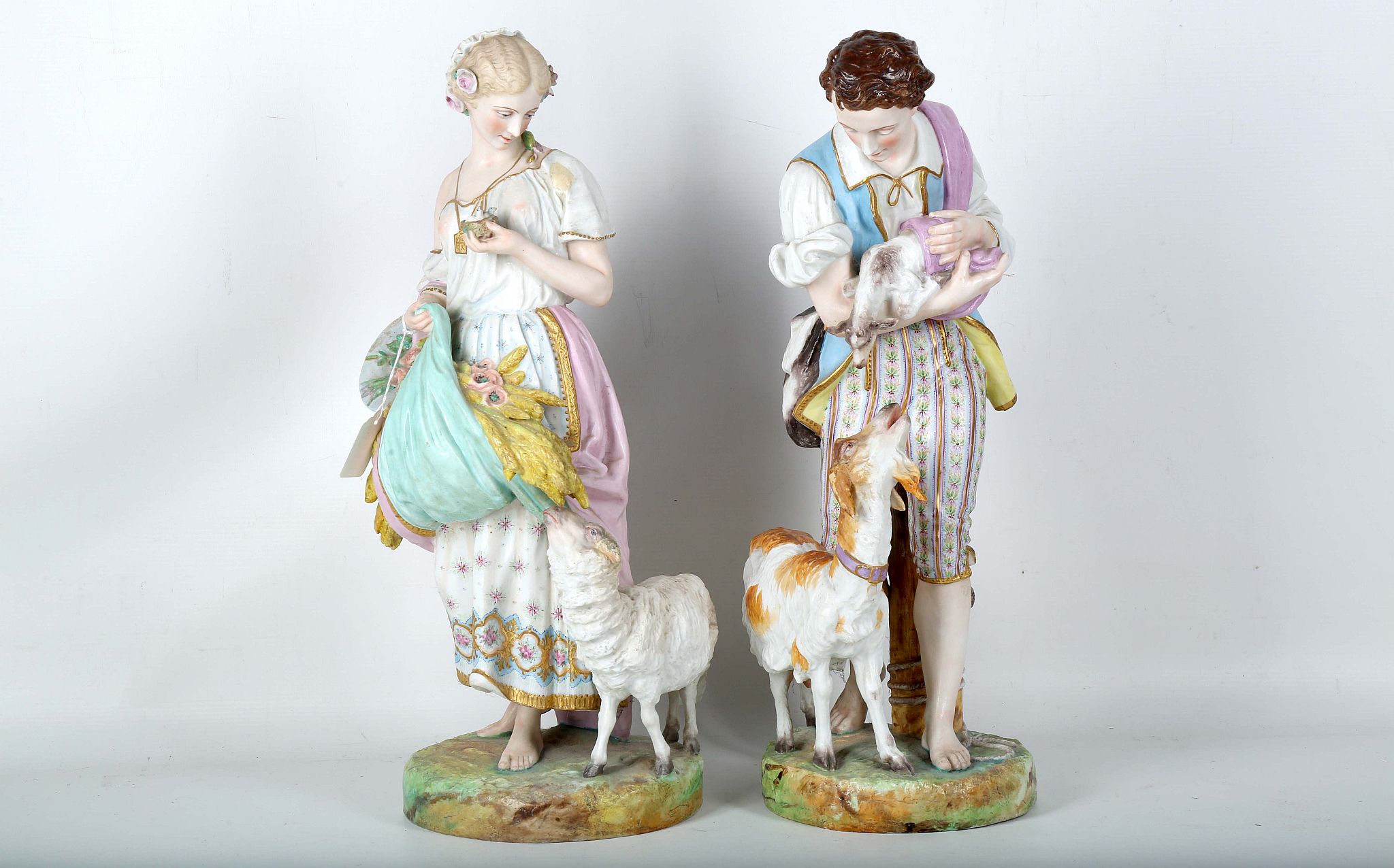 A pair of 19th Century Villeroy Boch Dresden Bisque figures of a pastoral boy and girl with sheep