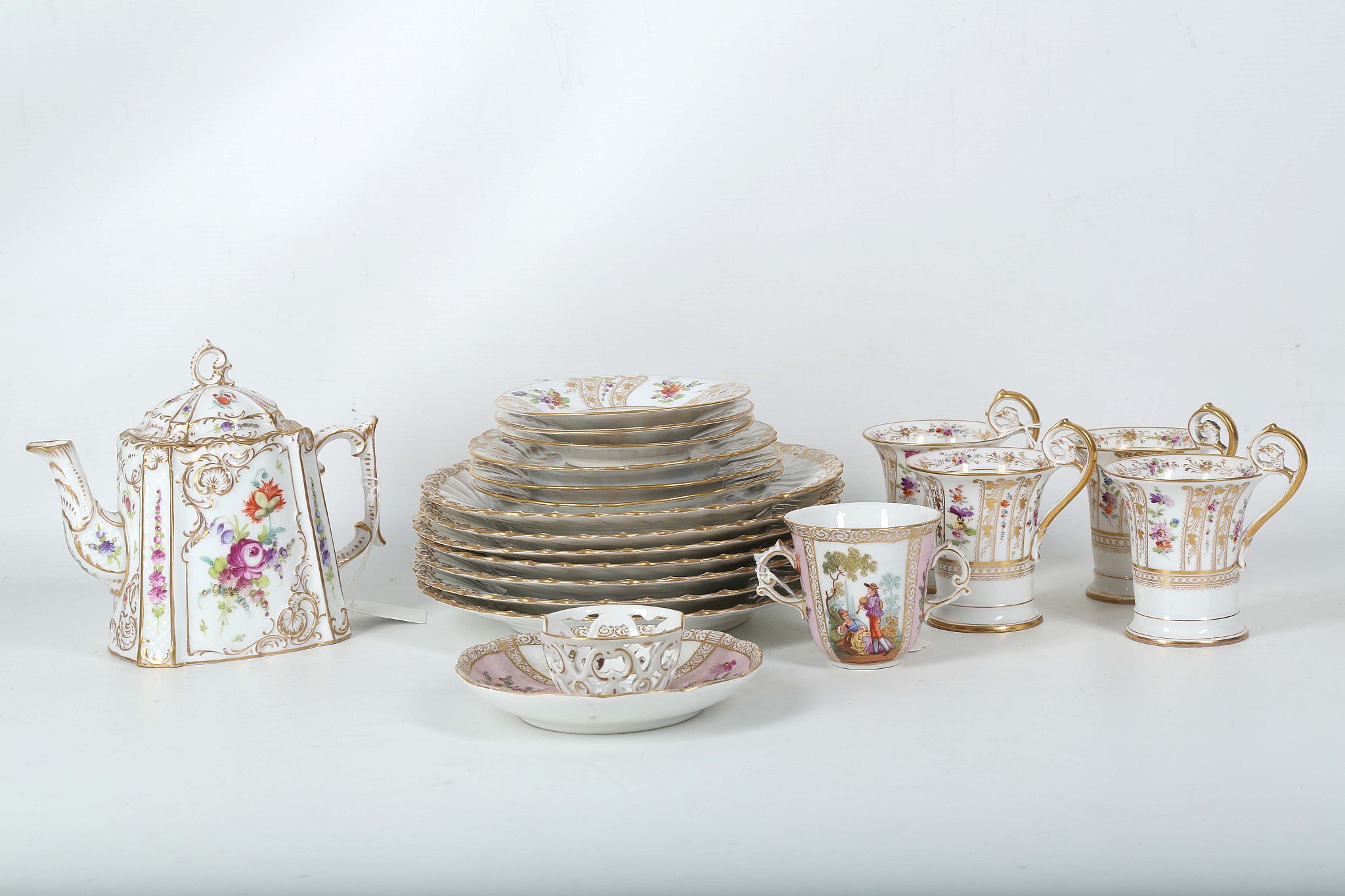 A collection of Dresden porcelain tea and dinnerware, late 19th Century, finely painted in the