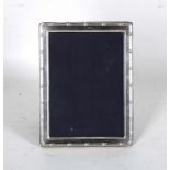 A modern Sheffield hallmarked silver photograph frame, having plain border, blue velvet back and