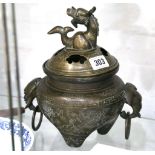 A late 19th Century Chinese bronze incense burner and cover, the top cast with mythical beast,