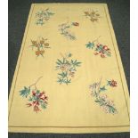 A hand stitched rug having beige ground, overworked with scattered flower sprays, 2.47m x 1.51m.