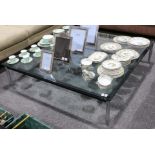 A large contemporary metal coffee table, raised on chromed legs with glass top, 140 x 140 x 30cm.