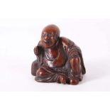 A CHINESE BAMBOO CARVING OF A BUDDHA. Seated beside a pillow with the mouth open and the left hand