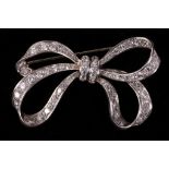 A diamond and platinum diamond ribbon bow brooch.