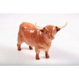 A Beswick porcelain figure f a long-horned highland cow, stamped 'Beswick, England', 13cm high.