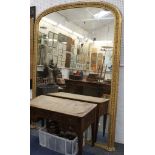 A large dome topped over-mantle gilt wall mirror, with raised decorative moulding and gadrooned