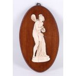 A Victorian ivory relief figure of Psyche, mounted onto an oval mahogany plaque.