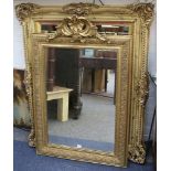 A large Victorian gilt framed mirror with swept corners, mirror size: 92 x 67cm, frame size: 124 x