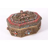 A Nepalese coral and turquoise inlaid hexagonal box with a seated Buddha in the centre of the cover,