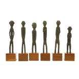 SIX INDONESIAN WOODEN FIGURES Of stylised form, standing with legs apart and three with their