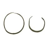 TWO EUROPEAN BRONZE TORCS Bronze Age, early 1st Millennium B.C. The larger of plain tubular form,