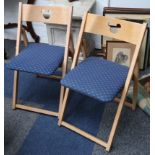 A pair of beech folding chairs, from cruise liner 'Disney Magic', the backs carved with an image