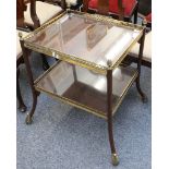 A two tier mahogany Empire style side table, with pierced brass galleries and acorn finials,
