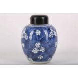 A Chinese blue and white pot with  wooden cover, decorated with a floral pattern around the body
