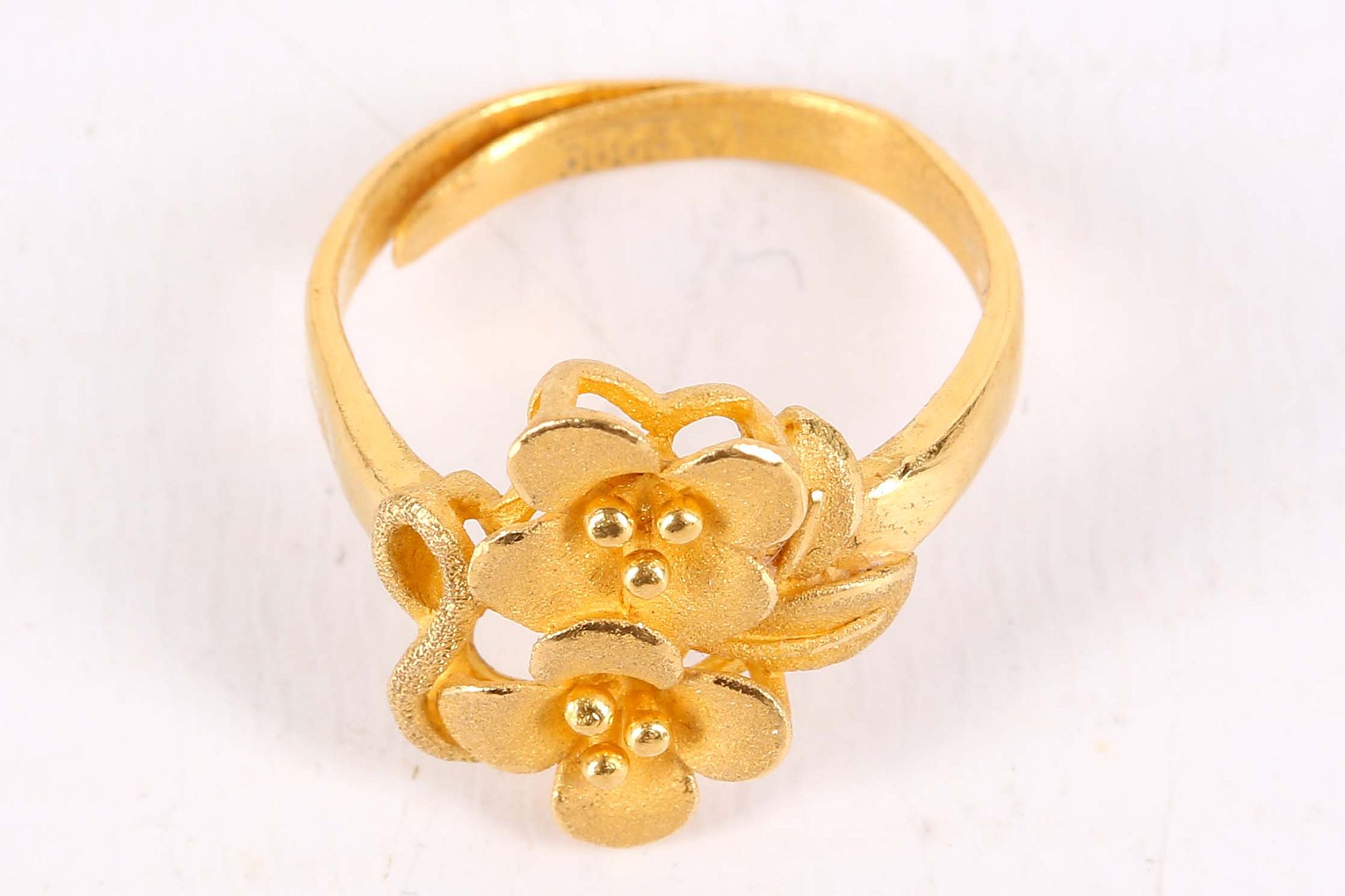 A flower ring, The two brushed flowerheads, stamped '9999', ring size L, approx. weight 4.7 grams.