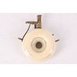 A 19th Century ivory powder flask with brass top, the flask 7cm diameter
