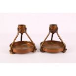 A pair of Austrian secessionist copper and brass candle stands, c.1910, base: 11cm diameter).