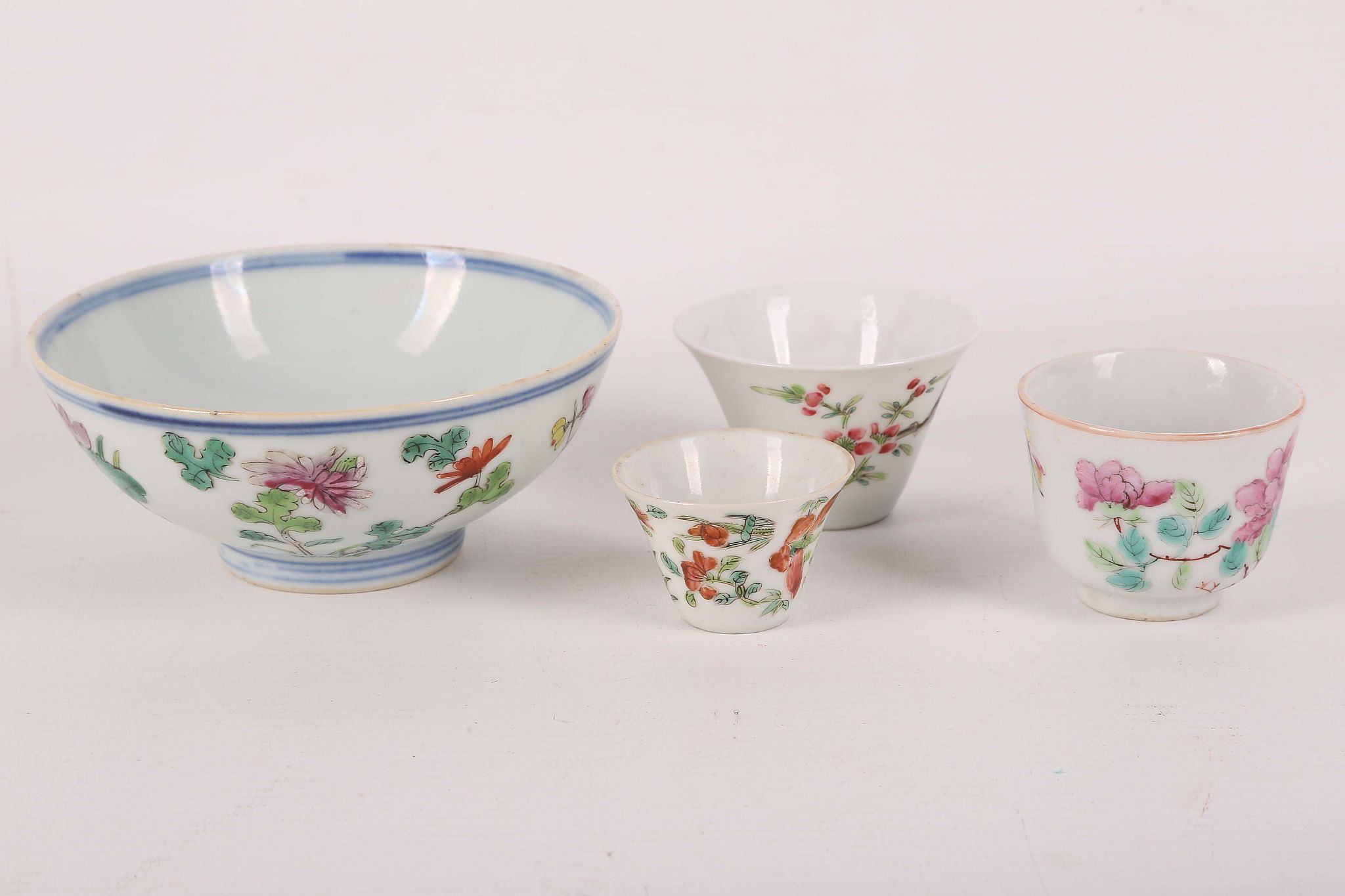 A collection of three Chinese famille rose cups; together with a bowl