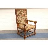 An antique walnut armchair, with floral needlework seat and back, on barley twist supports.