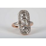 A continental Art Deco 18ct rose gold and diamond set panel dress ring, the platinum set stones