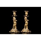 A PAIR OF MID 19TH CENTURY FRENCH GILT BRONZE ROCOCO STYLE CANDLESTICKS each modelled as a putto