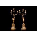 A PAIR OF 19TH CENTURY FRENCH GILT BRONZE FIGURAL CANDELABRA each modelled as a standing putto