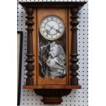 A Vienna regulator style wall clock with ebonised turned supports.