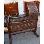A late 19th Century Victorian mahogany and beech cradle with turned supports, the mahogany cradle