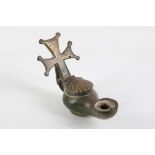 An antique bronze Christian oil lamp with cross, the lid cast as a shell.