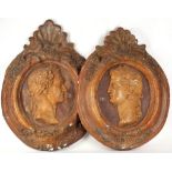A pair of deep relief moulded Roman portrait heads on cartouche panels, with shell motifs to tops,