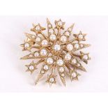 A gold and seed pearl star brooch