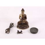 A 20th Century gilded brass model of a seated Buddha, an 18th Century cast metal weight, an